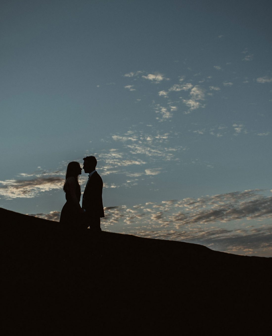 Couple silhouetted by the sky in Scotland