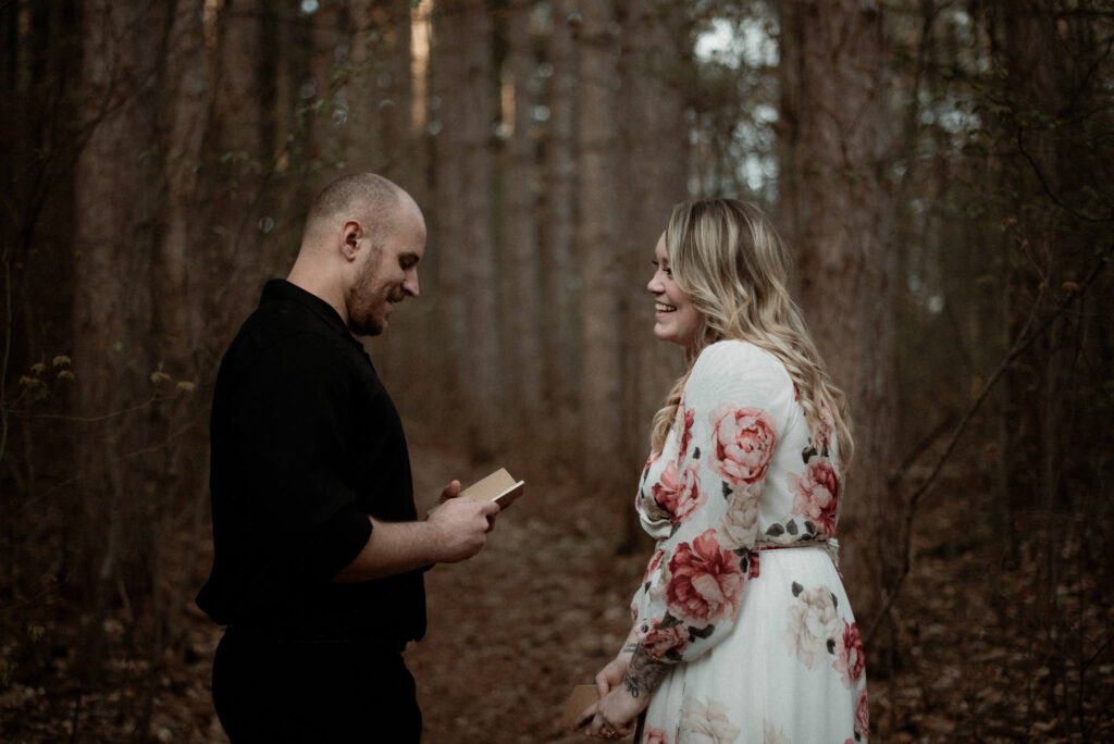 Couple smiling at each other during an intimate woodland elopement in Michigan.