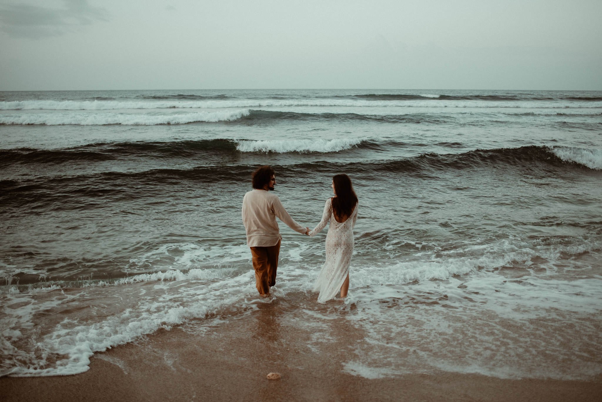 Elopement couple walking into the sea together