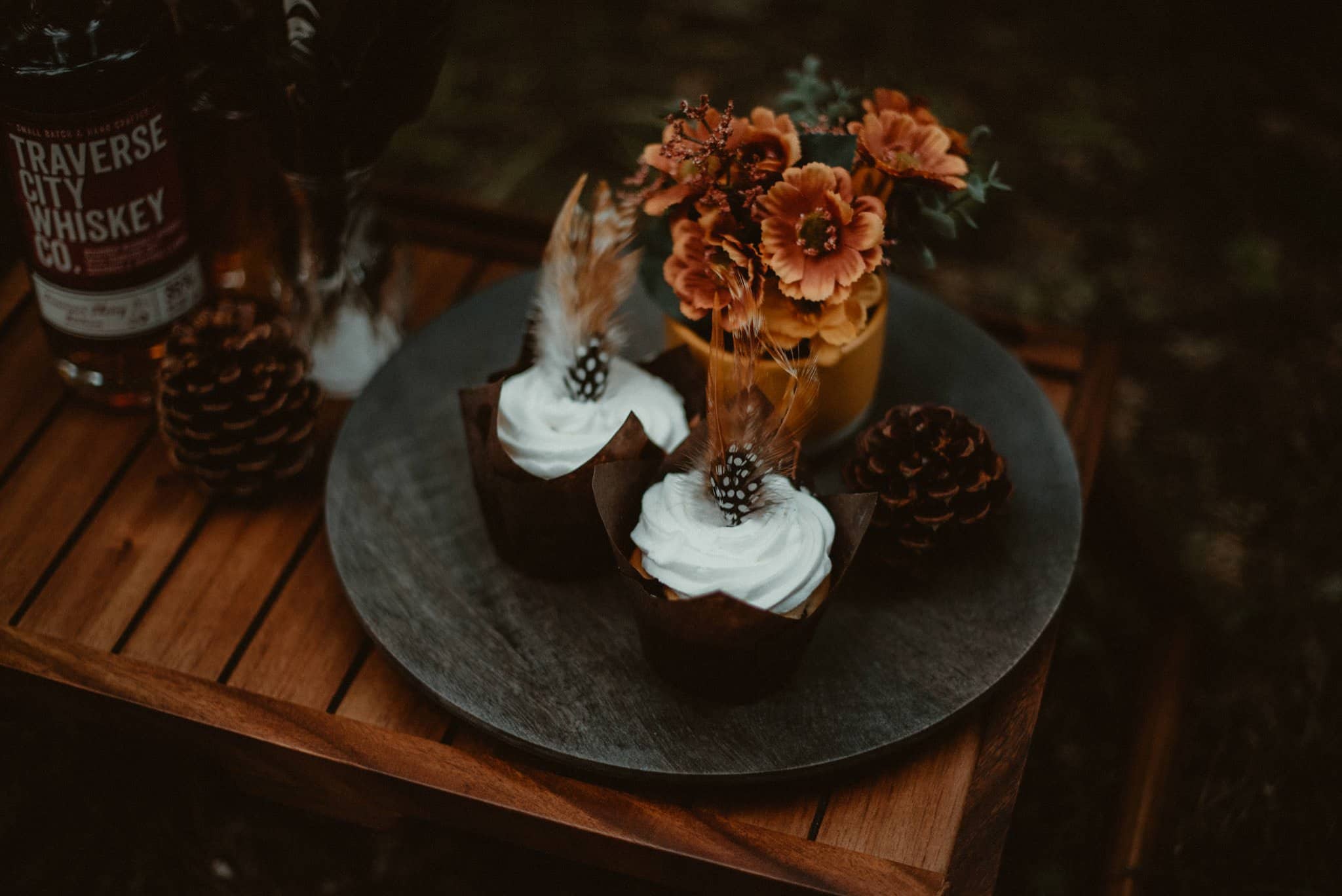 Fall wedding cupcakes on platter with pheasant feathers.