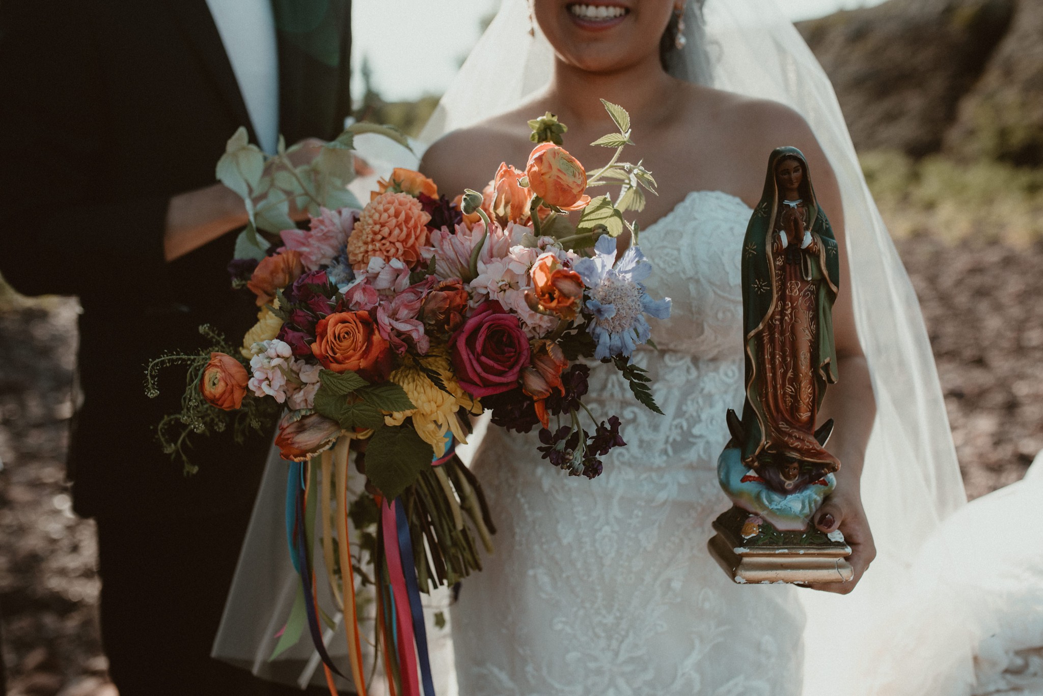 The bride holding her bouquet and a statue of Mary