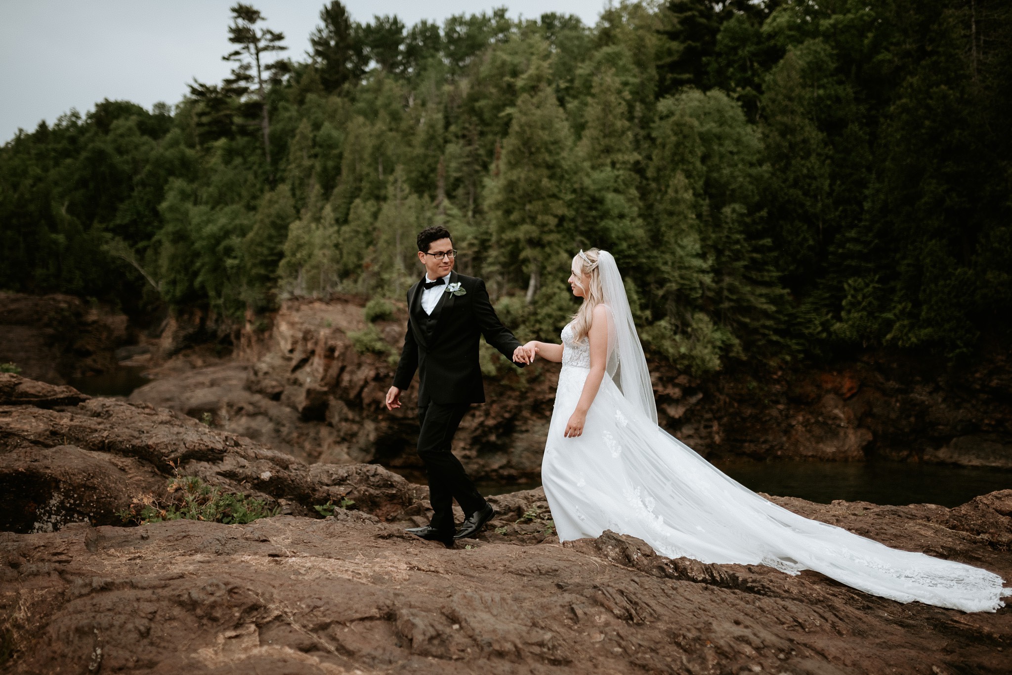 Bride and groom walking holding hands at their elopement in Marquette, Michigan.
