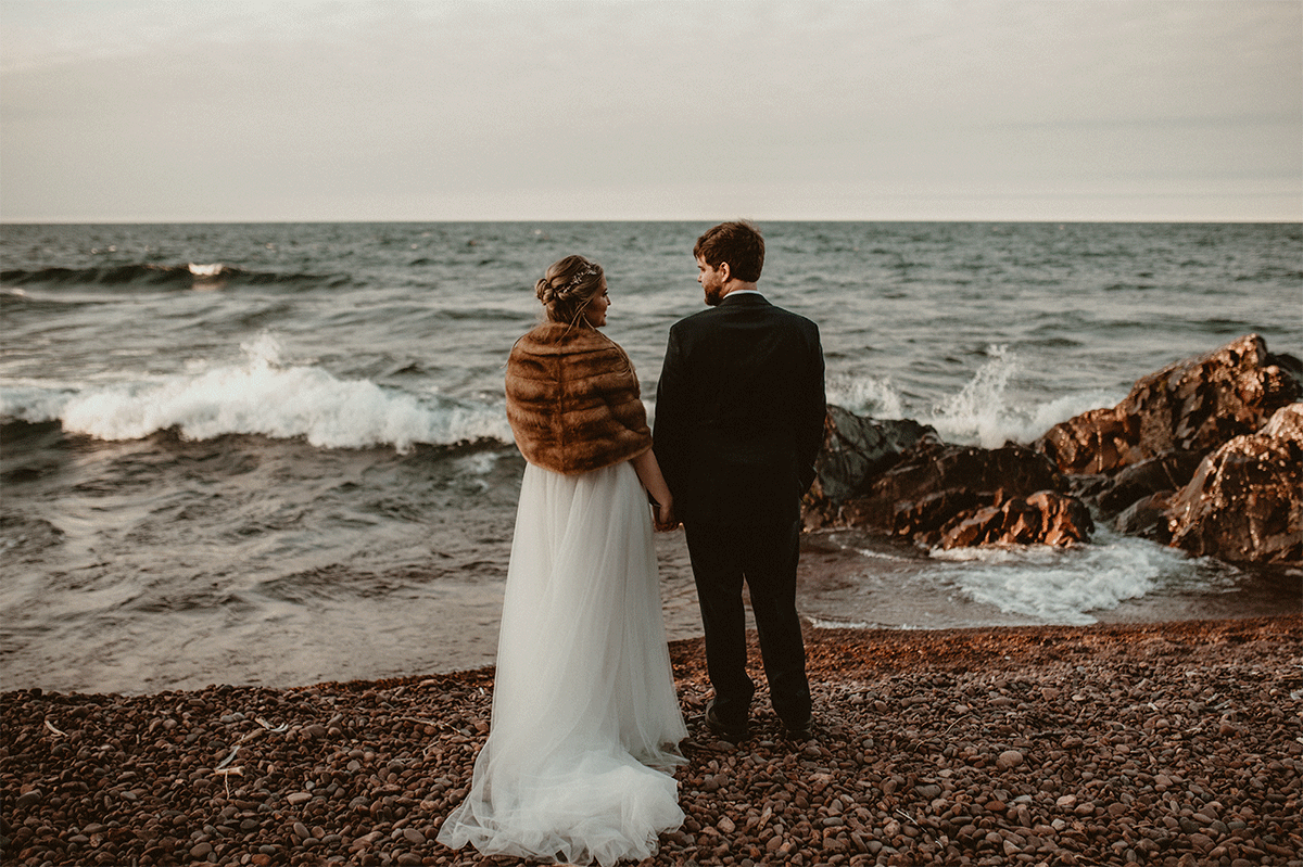 Bride and groom standing on the edge of Lake Superior at an elopement in Copper Harbor, Upper Peninsula of Michigan