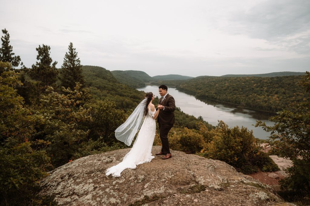 Couple holding hands at Lake of the Clouds overlook during their Porcupine Mountains elopement