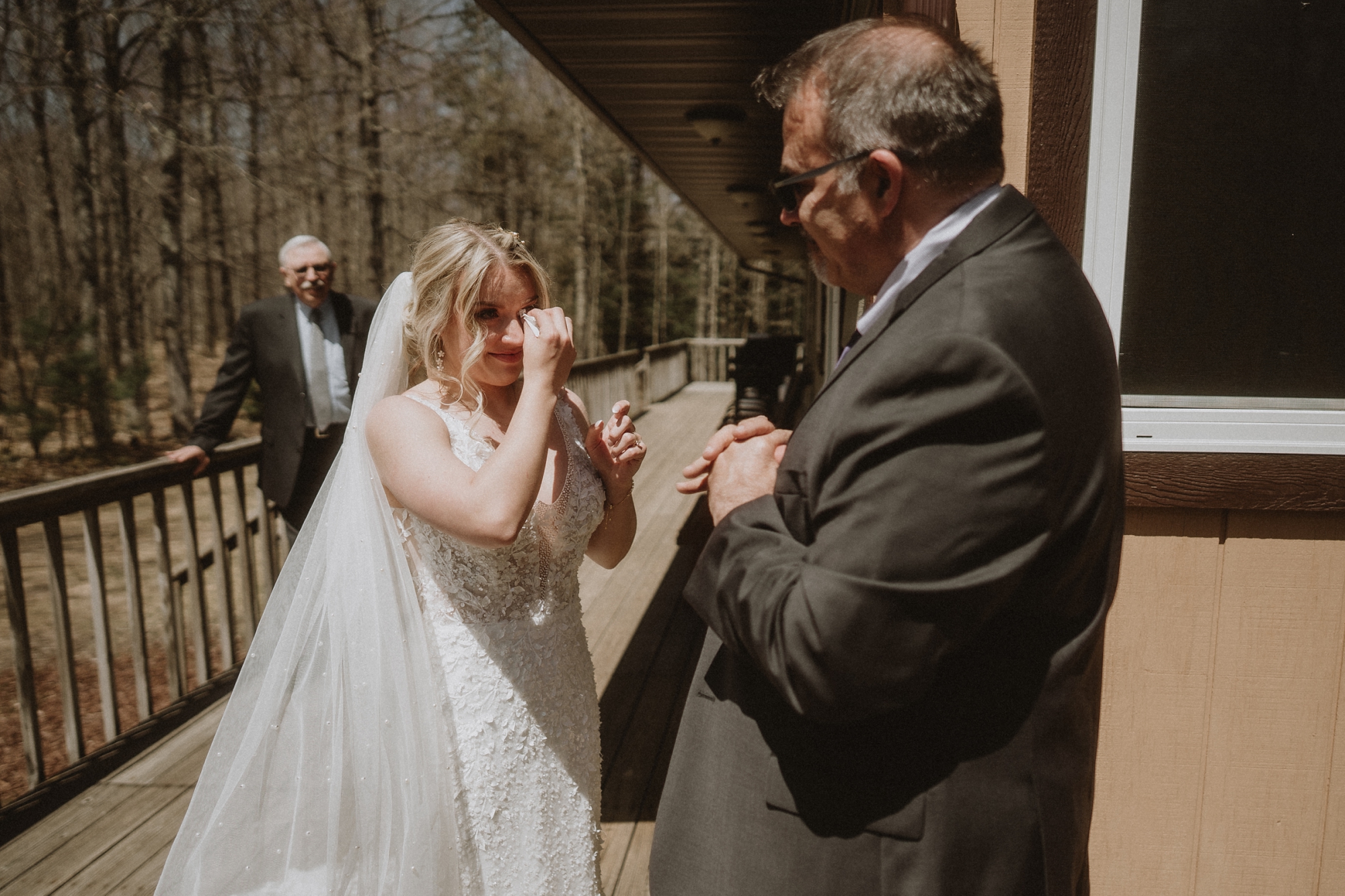 Bride laughing and wiping away tears while standing with officiant during outdoor Michigan elopement ceremony